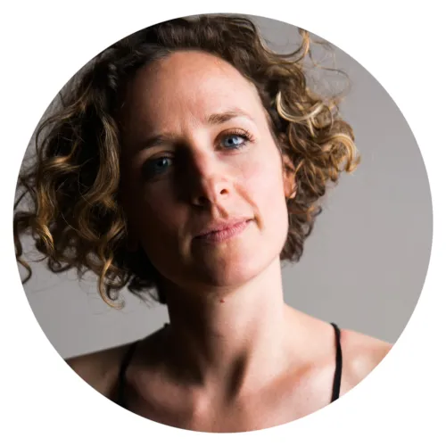 Headshot of a woman with short curly blodne-brown