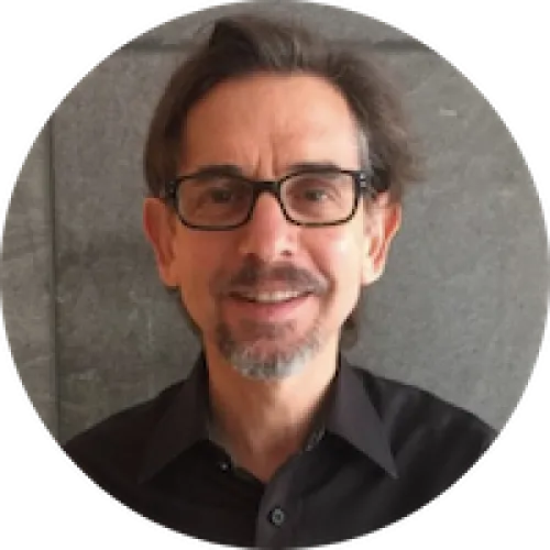 headshot of man with short hair and gray beard wea